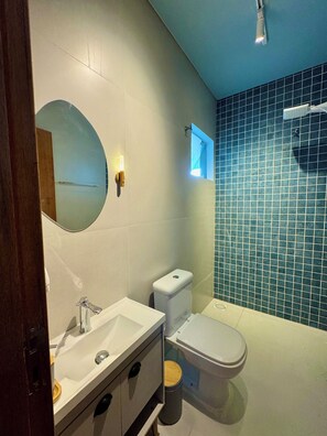 A modern bathroom with a white sink, a toilet, and a mirror. - Prado Guest House (Florianópolis)