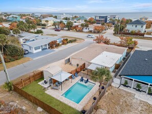 Un barrio residencial con casas, piscina y vista al océano.