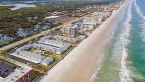 Um hotel à beira-mar com vários edifícios, praia e marina.