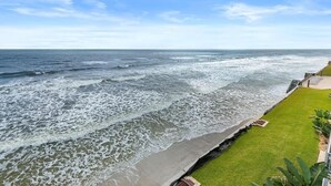 A coastal view with a grassy promenade overlooking the sea.