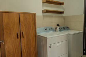 A laundry area with a wooden wardrobe and two white washing machines. - Hermosa casa, con Parqueo propio, Ideal para pasar momentos en familia o pareja. (Jocotenango)