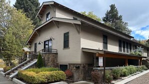 Un bâtiment à deux étages, doté de fondations en pierre, d’un porche couvert et d’un escalier menant à un balcon.