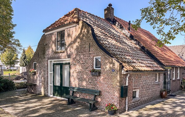 A brick building with a steeply pitched roof, a green door, and a number 31 sign.
