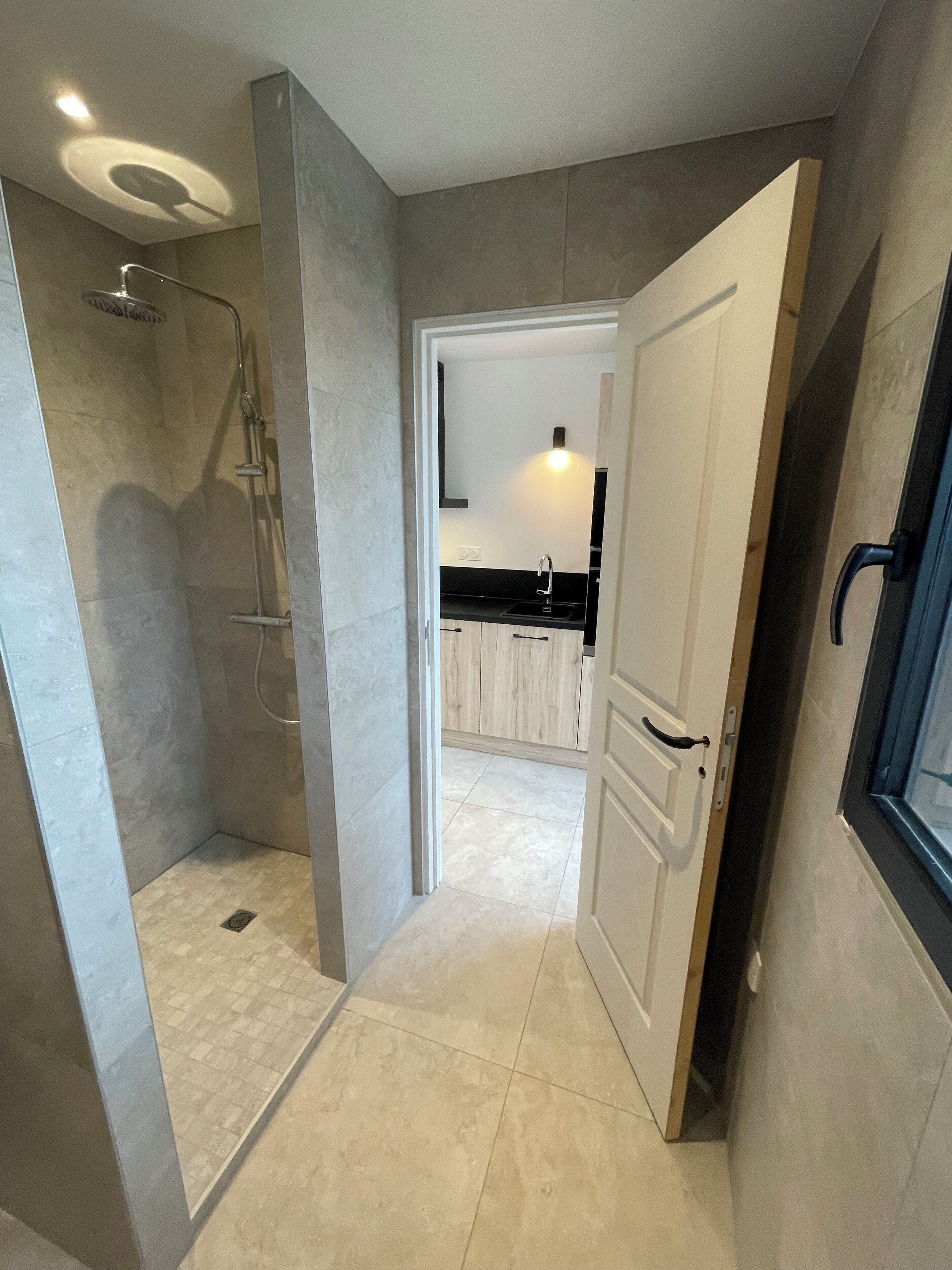 Een moderne badkamer met een douche, toilet en wastafel.