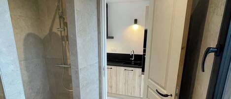 Een moderne badkamer met een douche, toilet en wastafel.