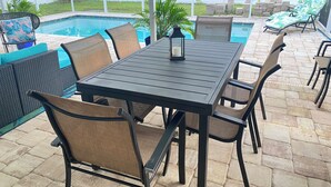 An outdoor patio with a pool, a table with chairs, and lounge chairs. - Near beach• Hot tub• Heated pool• Fenced yard •Carport• Pet friendly•Private (Venice)