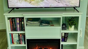 A flat-screen TV on a white entertainment center with a fireplace below it. - Near beach• Hot tub• Heated pool• Fenced yard •Carport• Pet friendly•Private (Venice)