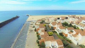 A coastal residential area with houses, a pier, and a beach.