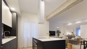 Eine moderne Küche mit Kochinsel, integrierten Geräten und einer Essecke mit Sofa und Tisch.