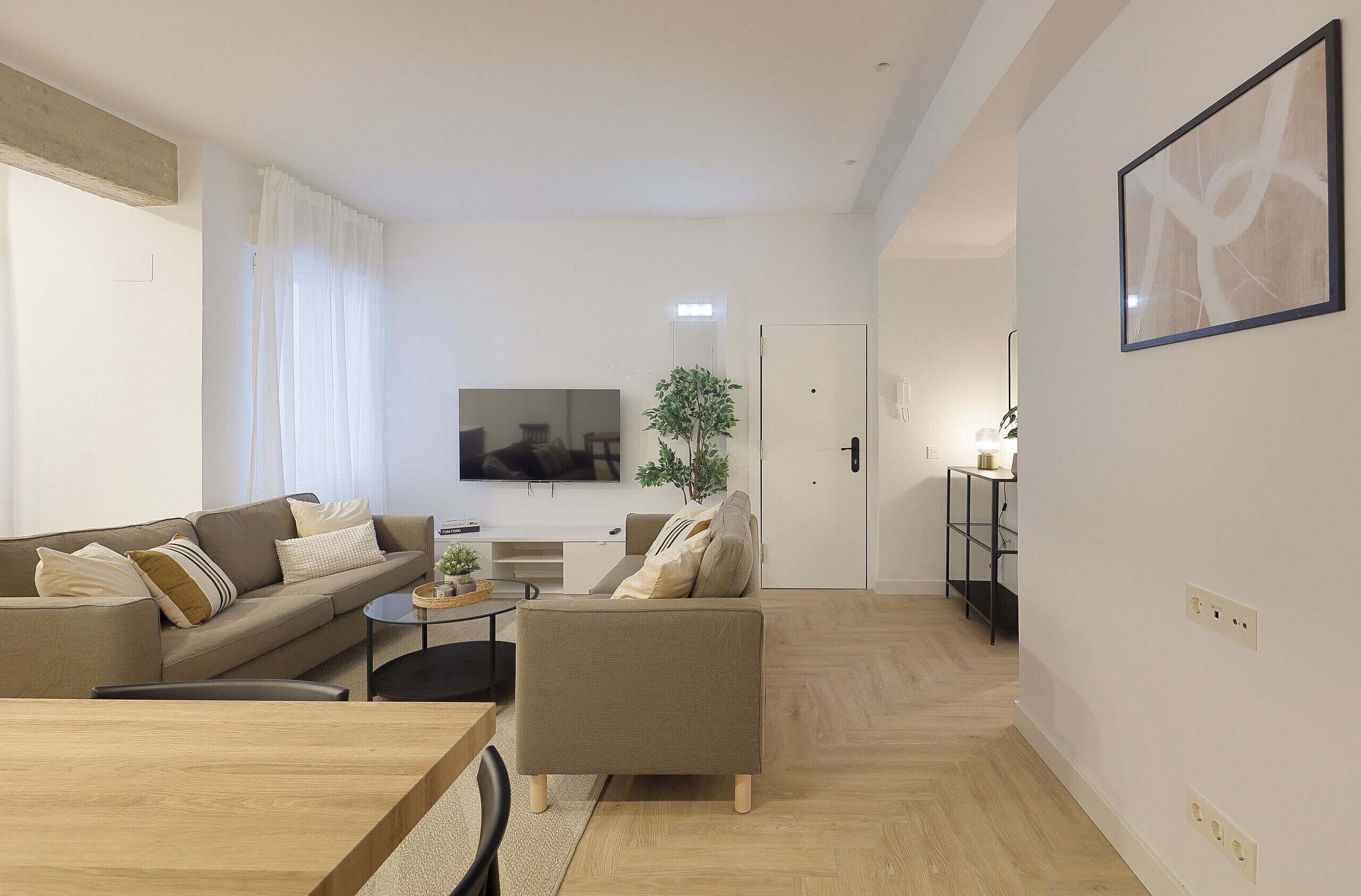 A modern living room with a sofa, a coffee table, and a TV.