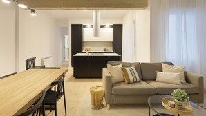Ein modernes Wohnzimmer mit einem Holzesstisch, einer Couch und einem Glastisch.
