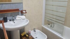 Un baño con lavamanos, espejo y bidé.