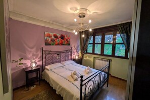 Une chambre à coucher avec un lit, une table de chevet et une fenêtre avec des rideaux.