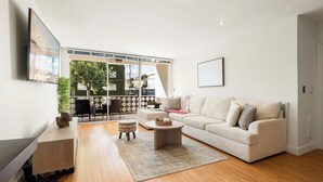 Un salon moderne avec un canapé, une table basse et un téléviseur fixé au mur.
