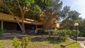 A building with a courtyard, surrounded by trees and plants. - Blue Skyline | Sea View Terrace in Portisco (Olbia)