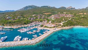 An aerial view of a coastal marina with numerous boats docked, surrounded by residential buildings and lush greenery. - Asfodeli - Flat with sea view and WiFi (Olbia)