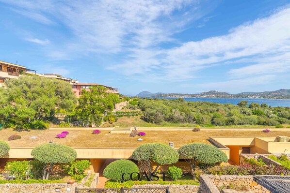 Une propriété située sur la côte, dotée de jardins en terrasses, offrant une vue sur la mer et s’ouvrant sur un paysage montagneux.