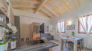 A modern living space with a kitchen area, dining table, and a sofa. - St. Simplicius - 5 mins from city center, WiFi, AC (Olbia)