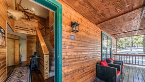 A wooden cabin with a covered porch, a staircase, and a mounted animal head. - Mescalero Cabin Pet Friendly | Your Adventure Basecamp w/ Grill, Decks & Cozy Comfort (Alto)