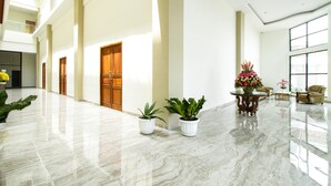 A spacious lobby with marble flooring, wooden doors, and potted plants. - Hotel Sepanak by Amazing (Central Curup)