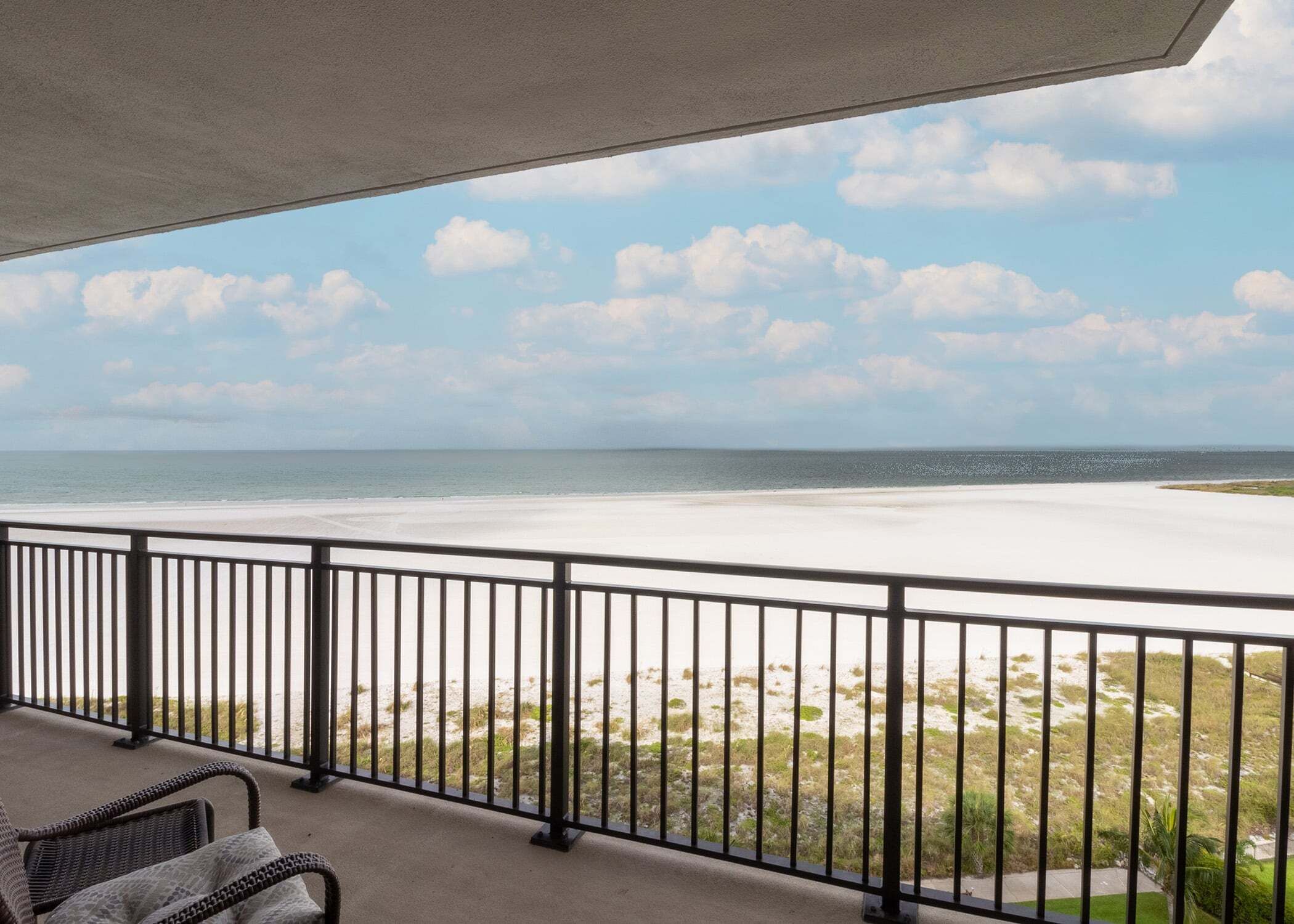 Un balcon avec vue sur une plage et l’océan.
