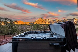 Un bain à remous avec vue sur les montagnes rocheuses au coucher du soleil.