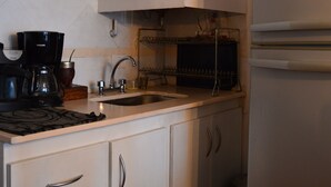 A kitchen with white cabinets, a coffee maker, a sink, and a refrigerator. - Siena I    (Villa Carlos Paz)