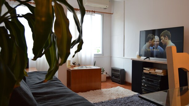 A living room with a television, a sofa, a coffee table, and a plant. - Siena I    (Villa Carlos Paz)