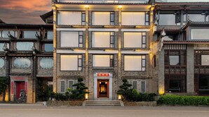 A traditional multi-story building with a prominent entrance, large windows, and a well-maintained garden. - Hidden Dragon Villa (Guilin)