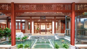 A traditional Chinese courtyard with a central water feature, wooden lattice roof, and potted plants. - Hidden Dragon Villa (Guilin)