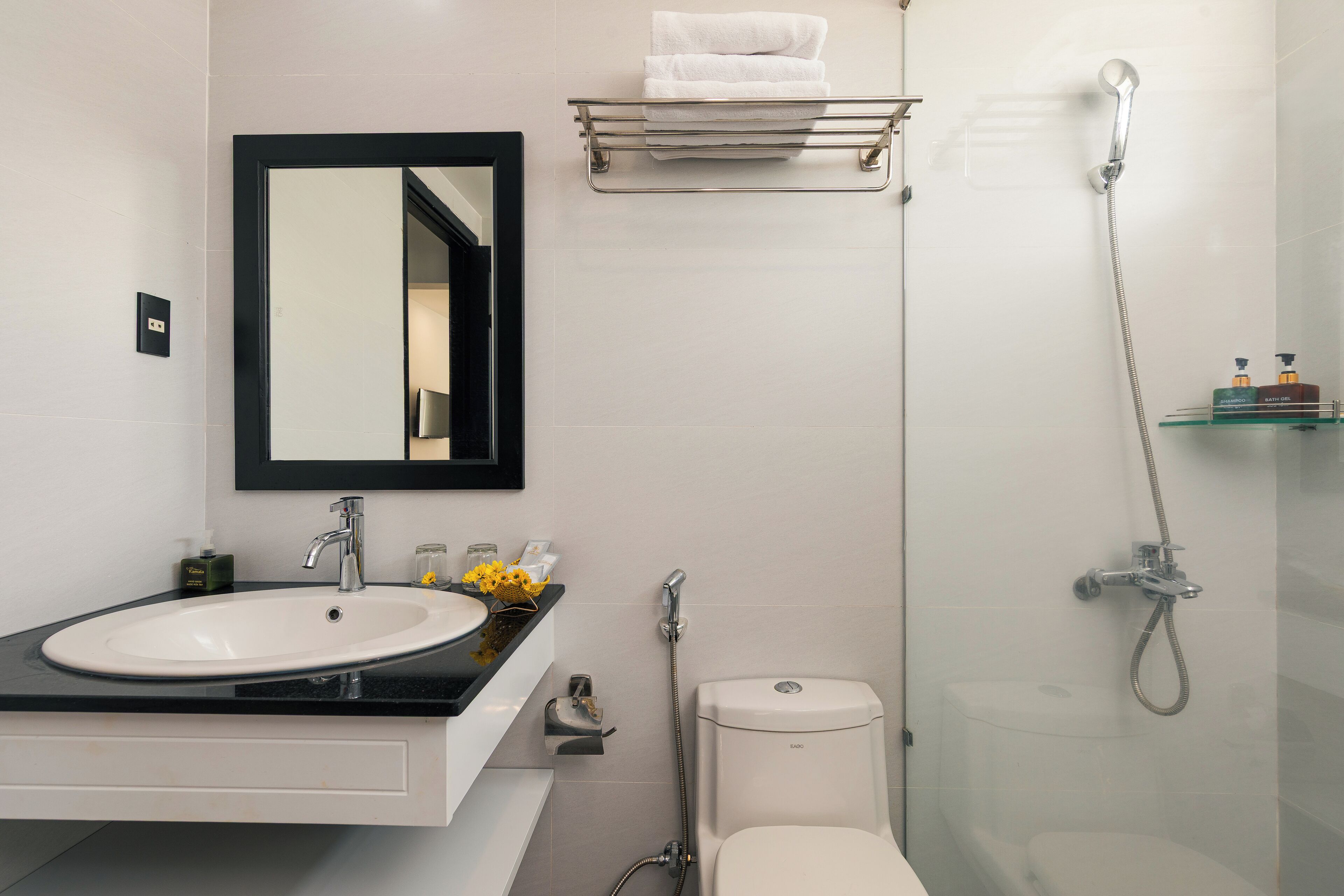 Un bagno moderno con un lavandino bianco, uno specchio, un water e una doccia.
