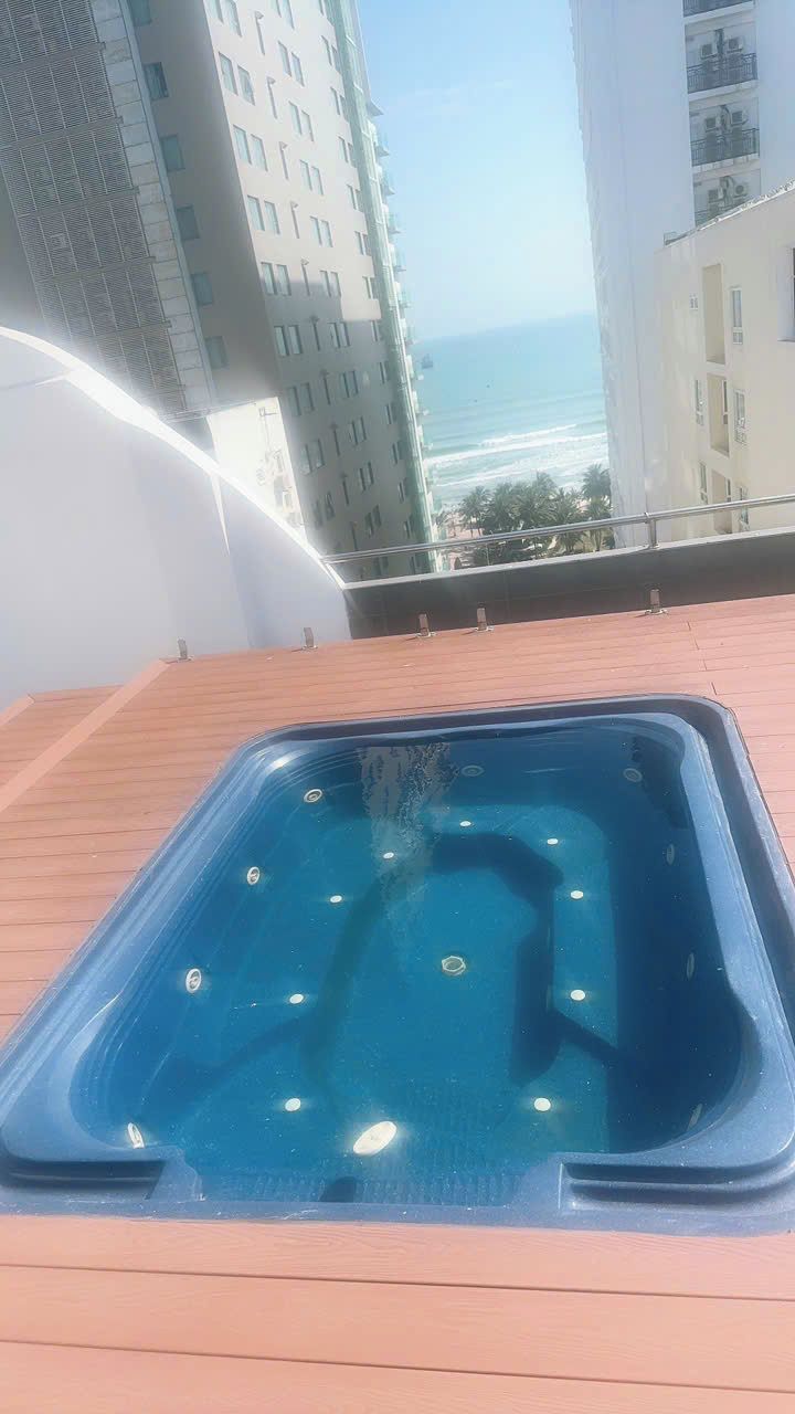 Une piscine sur le toit offrant une vue dégagée sur l’océan et les bâtiments environnants.