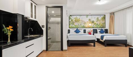 Habitación de hotel con kitchenette, dos camas, un ventanal con vistas y un cuadro en la pared.