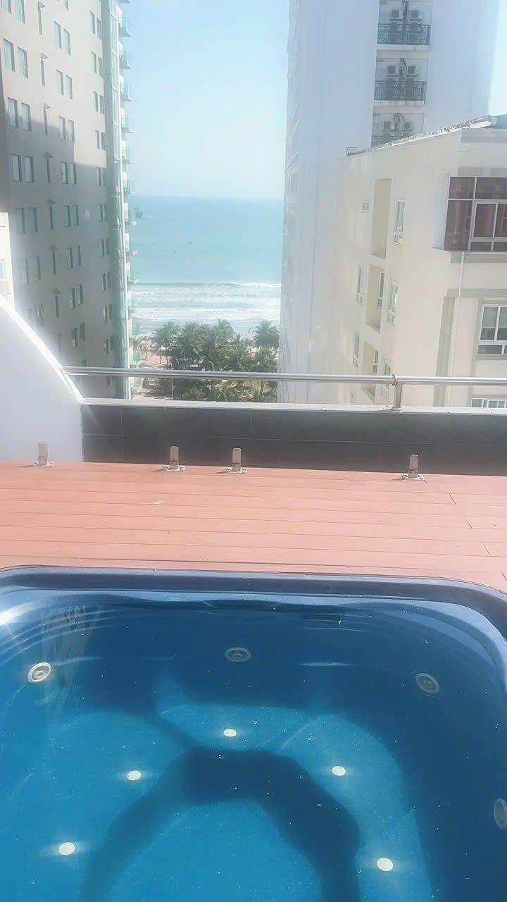 A rooftop pool with a view of the ocean and buildings.