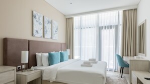 A modern hotel room with a large bed, a desk, a chair, and a window with curtains. - Unit 146 Seven Palm in Dubai (Dubai)