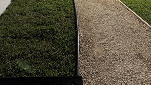 A well-maintained garden with a pathway, a small tree, and a white wall. - Nassau Hideaway: Steps away from the beach, Down Town, Cable Beach, PI & more.   (Nassau)