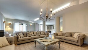 Amplia sala de estar con un sofá modular grande, una mesa de centro y una araña.