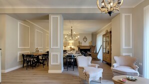 Un salón amplio con comedor, chimenea y candelabro.
