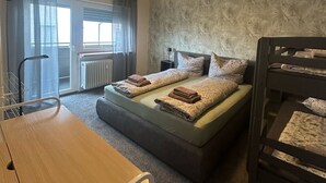 Un dormitorio con literas, un escritorio y una ventana con cortinas.