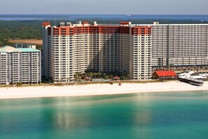 A large hotel complex with multiple high-rise buildings, a beachfront, and a calm sea. - 3b3ba | Gulf Front | Pool, Hot Tub | Beach Chairs! (Panama City Beach)