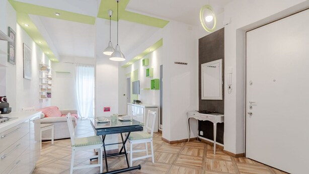 Una cucina moderna con un tavolo da pranzo, sedie e un armadietto bianco.