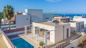 A rooftop pool area with a clear view of the sea and mountains in the background. - VILLA MONTFARRUTX - Modern villa with private swimming pool and free Wifi (Artà)