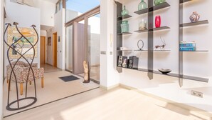 A modern interior with a dining area, open shelves with decorative items, and a clear view to the outside. - VILLA MONTFARRUTX - Modern villa with private swimming pool and free Wifi (Artà)