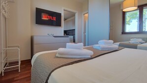 Une chambre d’hôtel équipée d’un lit, d’un téléviseur fixé au mur, d’une kitchenette et d’une fenêtre.
