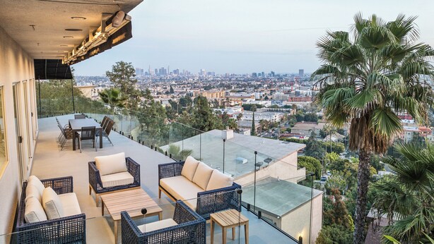 A rooftop terrace with outdoor furniture, a city view, and palm trees. - The Hollywood Hills Luxury Nest with Views, Pool and Spa. (Los Angeles)