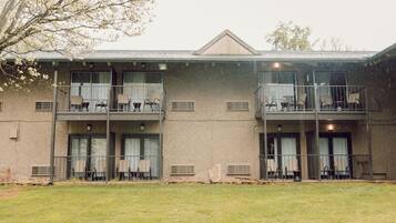 A two-story building with balconies and outdoor seating.