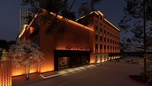 Un hotel moderno con fachada de ladrillo, ventanas amplias y una entrada bien iluminada.