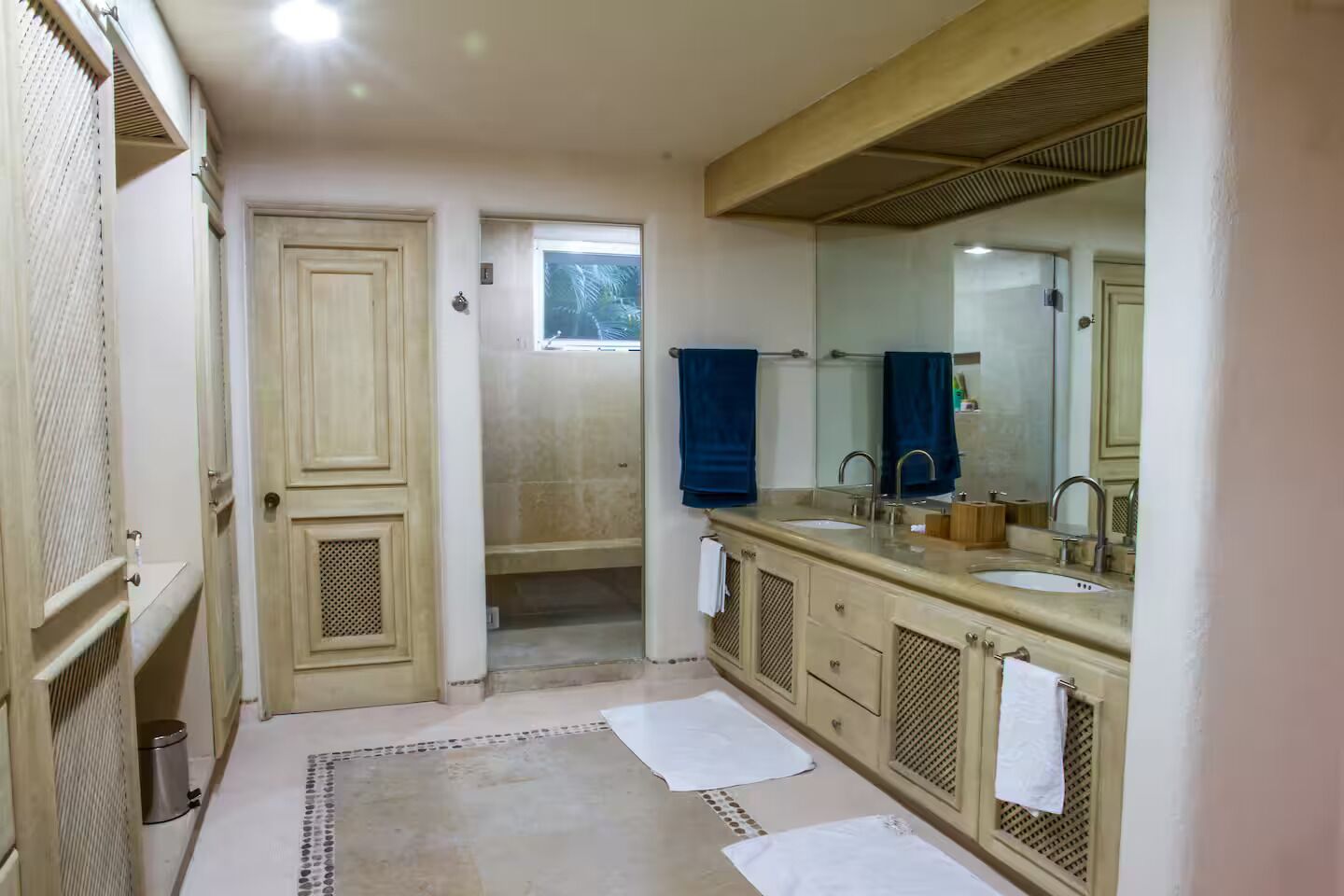 Une salle de bain avec un double lavabo, un grand miroir et un espace douche.