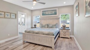 A bedroom with a bed, a nightstand, a ceiling fan, and a window with a view of the outdoors. - Touchdown Hideaway! Beach/OWA/Sports/Shopping (Foley)