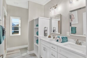 A modern bathroom with a large mirror, two sinks, and built-in shelves. - Touchdown Hideaway! Beach/OWA/Sports/Shopping (Foley)